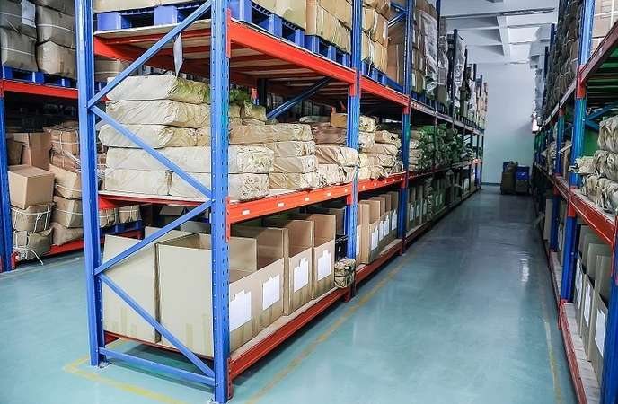 Long span shelving with stock totes in a tidy warehouse